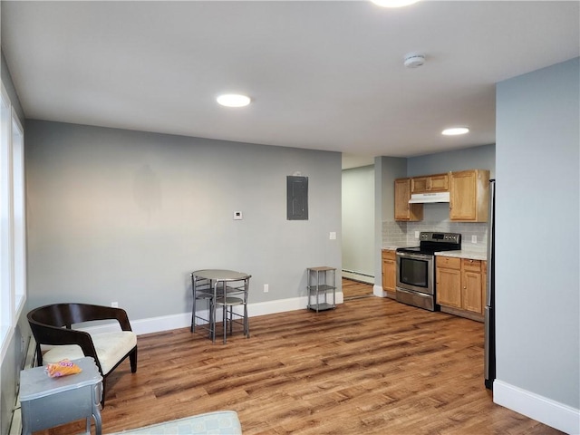 kitchen featuring tasteful backsplash, baseboard heating, electric panel, hardwood / wood-style flooring, and stainless steel appliances