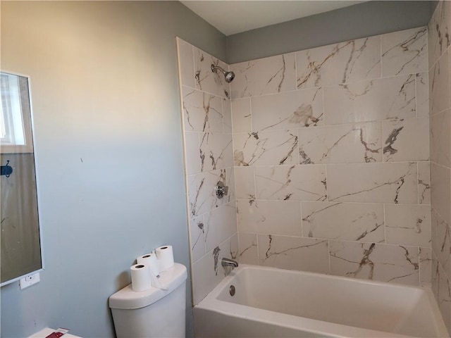 bathroom with tiled shower / bath combo and toilet