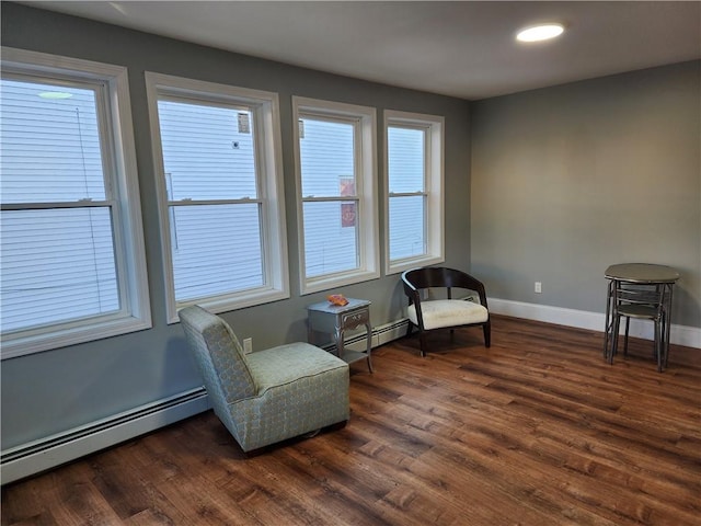 sitting room with dark hardwood / wood-style floors, a wealth of natural light, and a baseboard heating unit