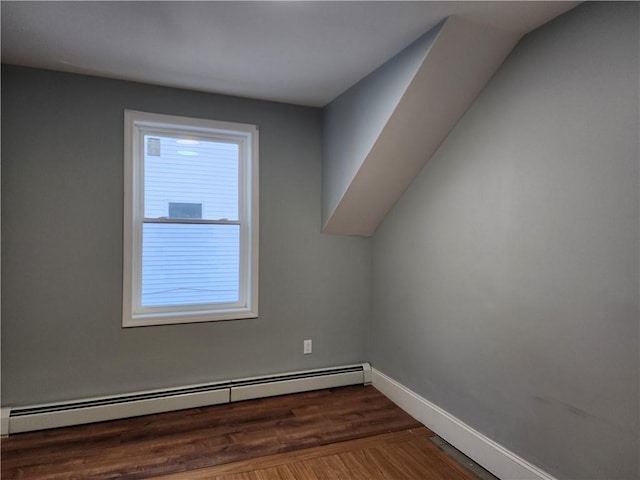 additional living space featuring dark hardwood / wood-style flooring, plenty of natural light, and baseboard heating