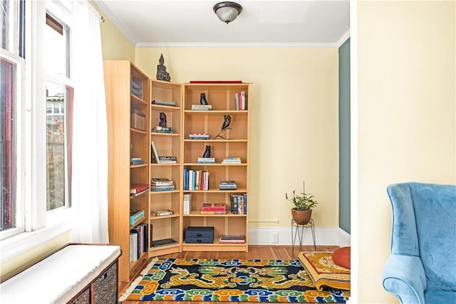 sitting room with hardwood / wood-style flooring and ornamental molding