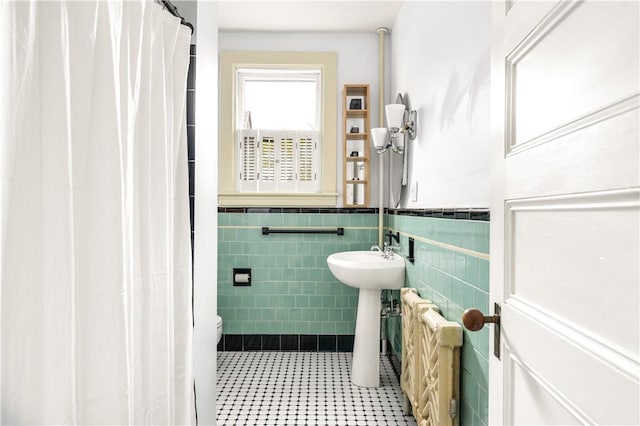 bathroom featuring toilet and tile walls