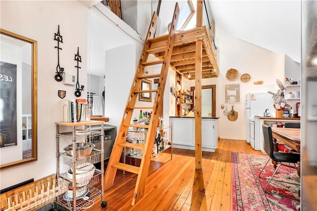 staircase featuring wood-type flooring and a towering ceiling