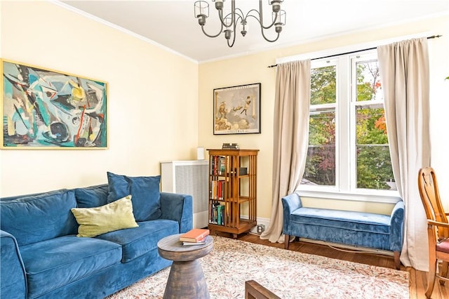 living room with ornamental molding, wood-type flooring, and a chandelier