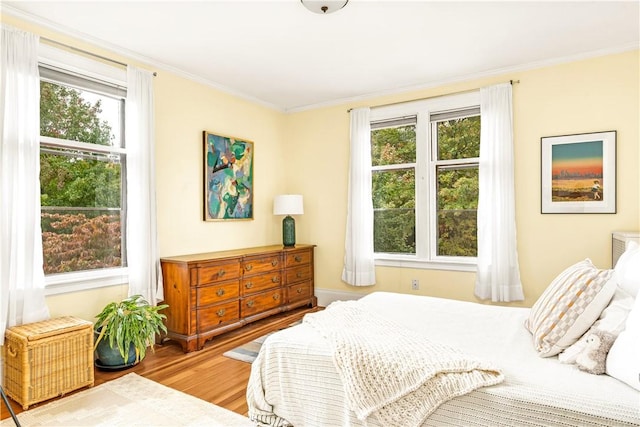 bedroom with hardwood / wood-style flooring and crown molding