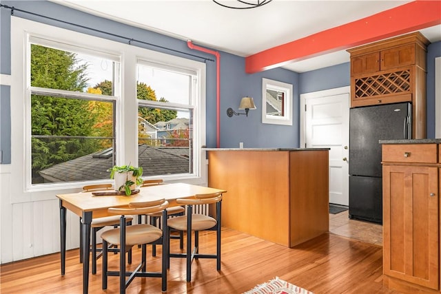 kitchen with black refrigerator and light hardwood / wood-style floors