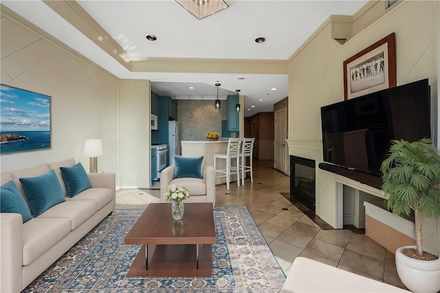 living area featuring light tile patterned flooring, a glass covered fireplace, recessed lighting, and crown molding