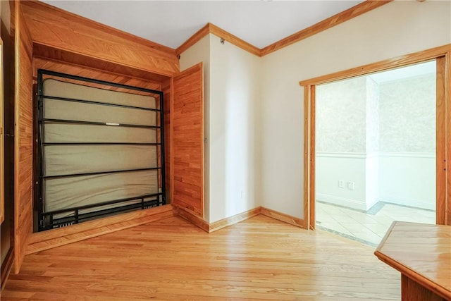 interior space with baseboards, light wood-style flooring, and crown molding