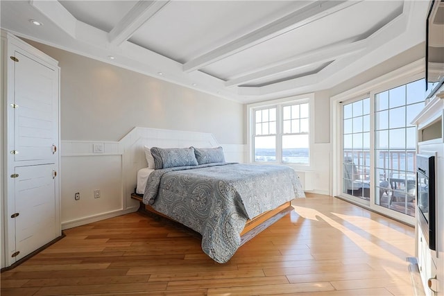 bedroom featuring beamed ceiling, a wainscoted wall, recessed lighting, light wood-style floors, and a fireplace