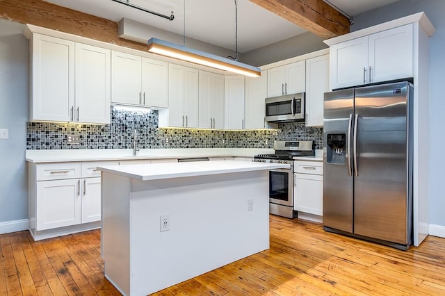 kitchen featuring white cabinetry, decorative light fixtures, tasteful backsplash, and stainless steel appliances