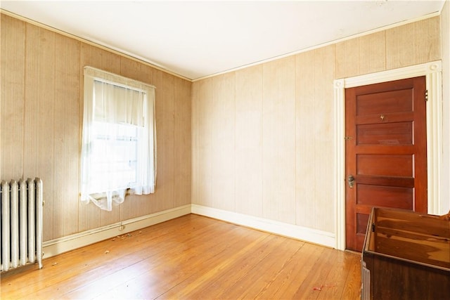 empty room featuring radiator and wood-type flooring