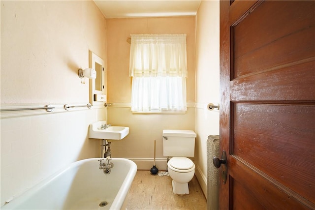 bathroom with sink, a washtub, and toilet