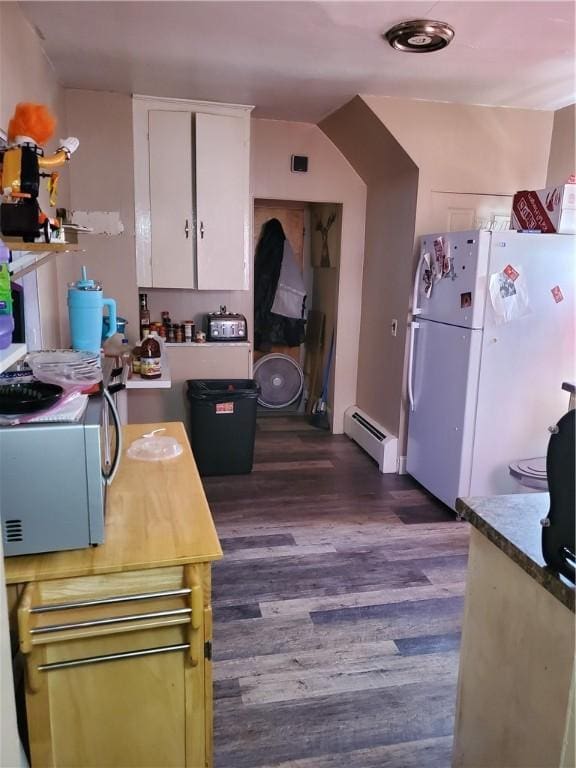 kitchen featuring a baseboard heating unit, dark wood-type flooring, white cabinets, and white fridge