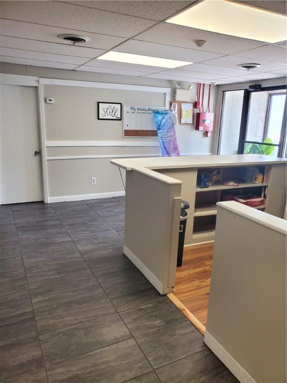 kitchen with a drop ceiling and dark tile patterned floors