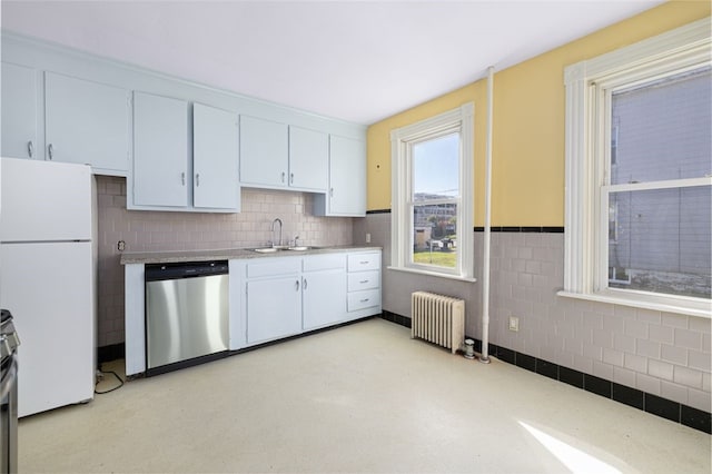 kitchen with white cabinetry, stainless steel appliances, radiator, and sink