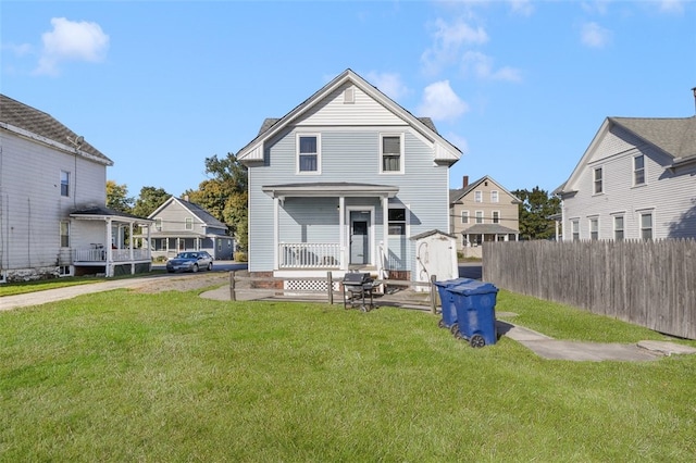 back of house with a yard and covered porch