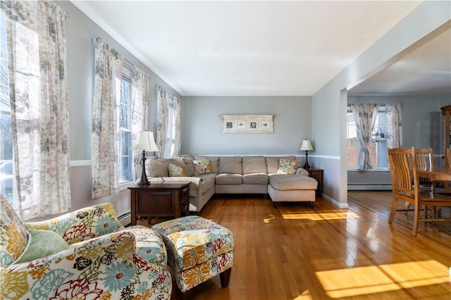 living room with a baseboard heating unit and hardwood / wood-style floors