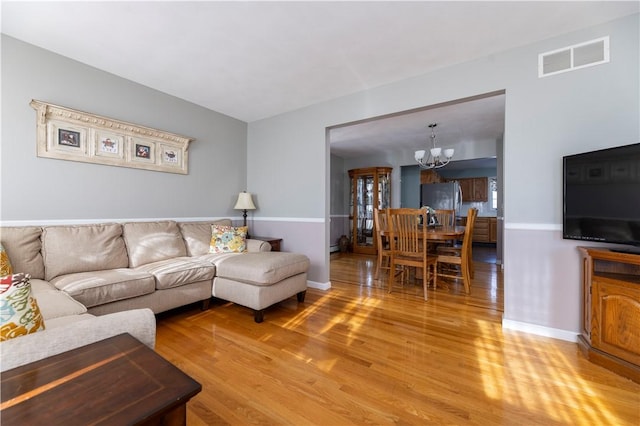 living room with light hardwood / wood-style floors and a chandelier