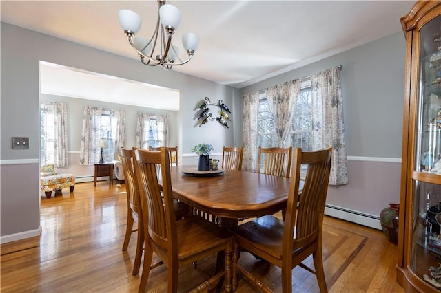 dining room with light hardwood / wood-style floors, a chandelier, and baseboard heating