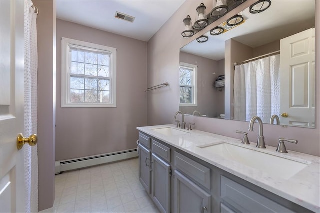 bathroom with vanity, plenty of natural light, and baseboard heating