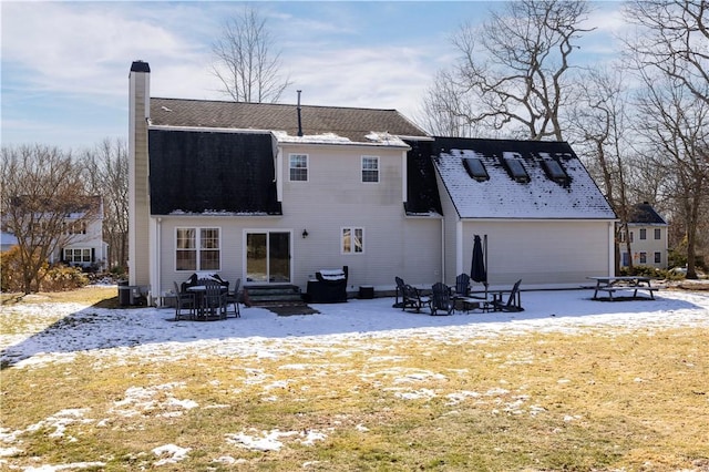 snow covered back of property featuring a patio area and a fire pit