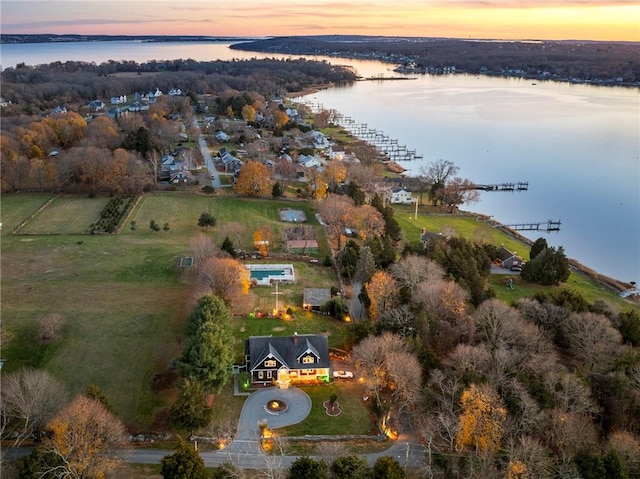 aerial view at dusk featuring a water view