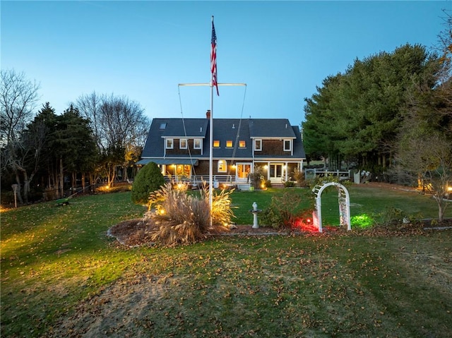 rear view of house featuring a lawn