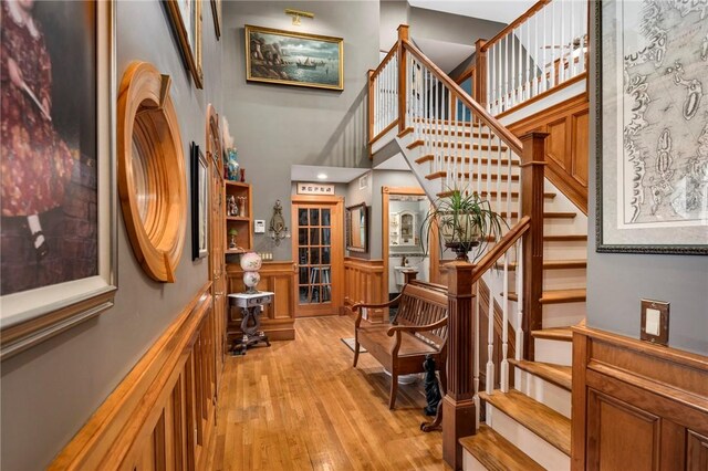 stairs with a towering ceiling and hardwood / wood-style floors