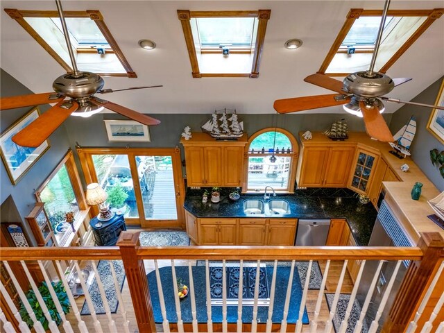 kitchen with sink, decorative backsplash, ceiling fan, and a skylight