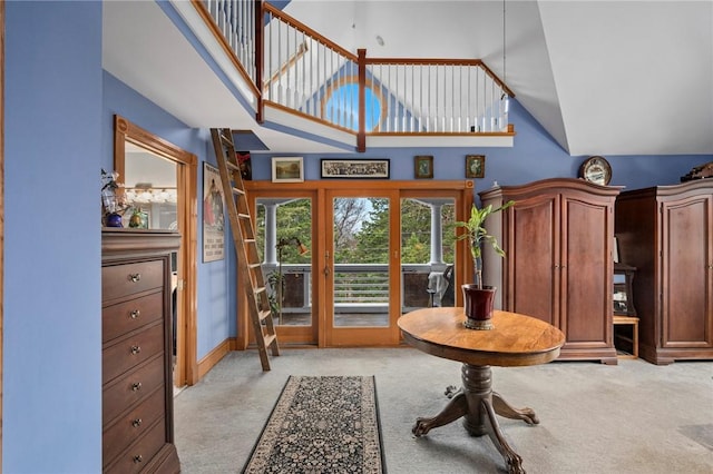 interior space featuring light colored carpet and high vaulted ceiling