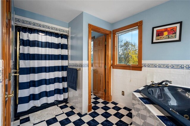 bathroom with tile walls and a relaxing tiled tub