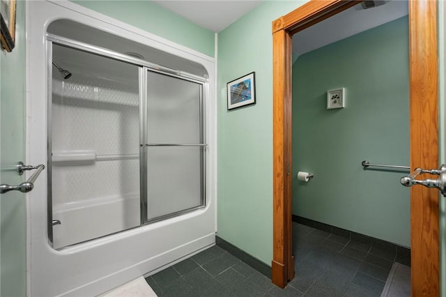 bathroom featuring shower / bath combination with glass door, tile patterned flooring, and baseboards