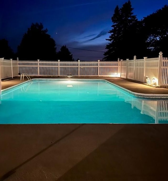 pool at twilight with fence and a fenced in pool