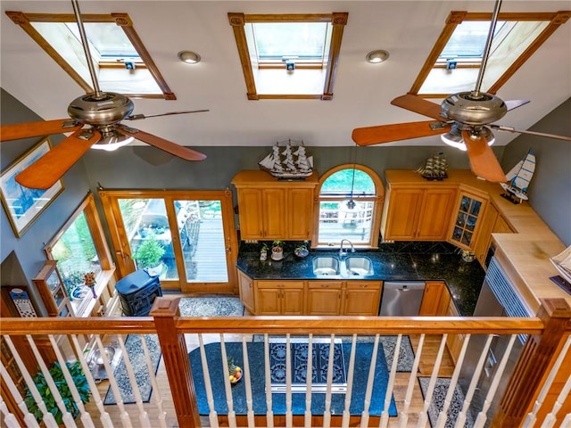 kitchen with tasteful backsplash, a skylight, a sink, and a ceiling fan