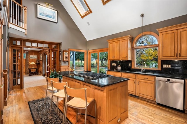 kitchen featuring light wood-style floors, a kitchen island, a sink, black gas stovetop, and dishwasher