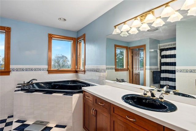 full bathroom featuring a bath, plenty of natural light, and tile walls