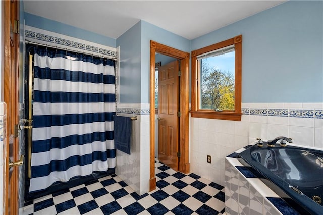 bathroom with tile walls, wainscoting, a shower with shower curtain, tile patterned floors, and a bath