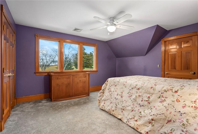 bedroom featuring lofted ceiling, ceiling fan, carpet flooring, visible vents, and baseboards