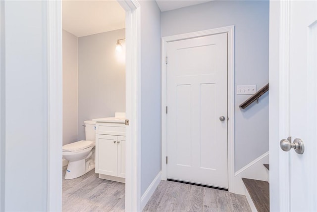 bathroom featuring wood-type flooring, vanity, and toilet