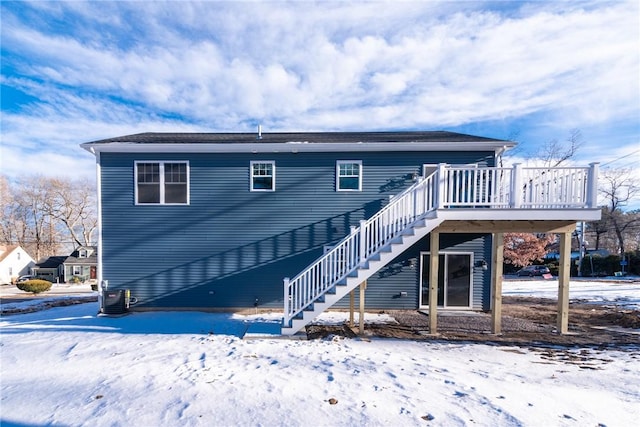 snow covered house featuring a wooden deck