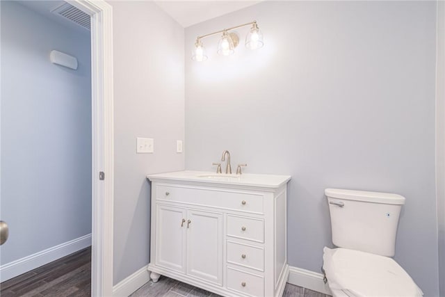 bathroom featuring hardwood / wood-style flooring, vanity, and toilet