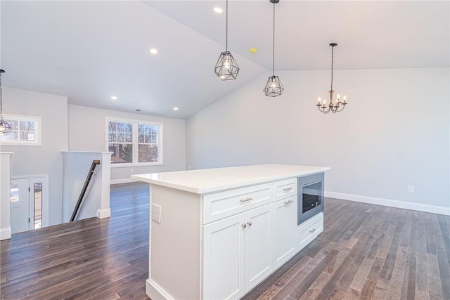 kitchen with dark hardwood / wood-style floors, built in microwave, white cabinets, hanging light fixtures, and a center island