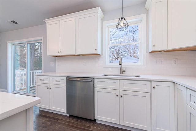 kitchen with sink, dark wood-type flooring, dishwasher, white cabinetry, and decorative light fixtures