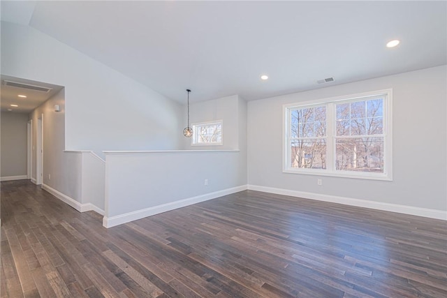 empty room with dark hardwood / wood-style flooring and vaulted ceiling