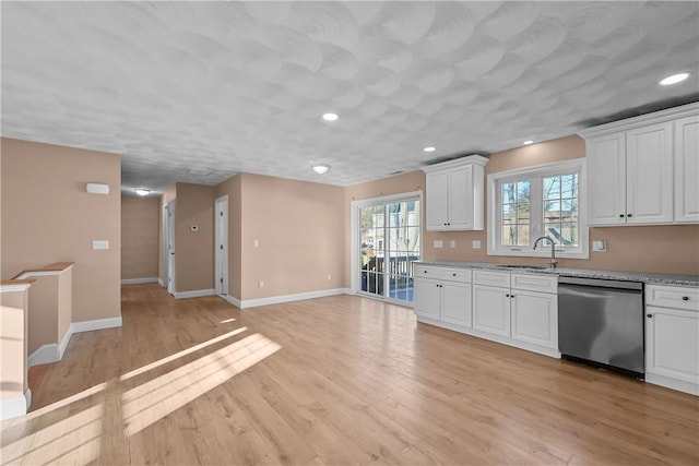 kitchen featuring dishwasher, sink, white cabinets, and light hardwood / wood-style flooring