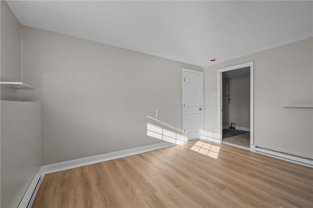 empty room featuring light wood-type flooring and baseboard heating