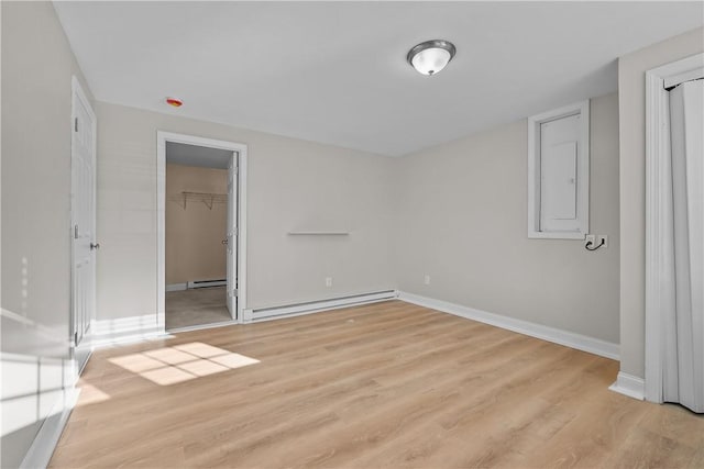 spare room with a baseboard radiator and light hardwood / wood-style floors