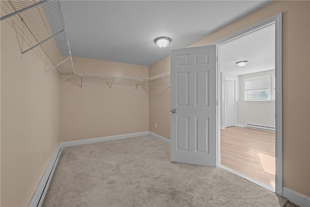 walk in closet with light carpet and a baseboard radiator