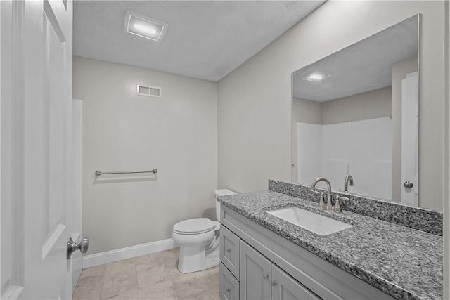 bathroom featuring vanity, a shower, and toilet