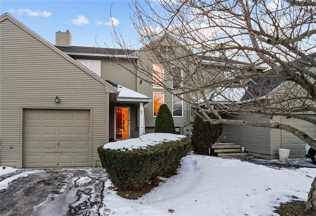 view of snow covered exterior with a garage